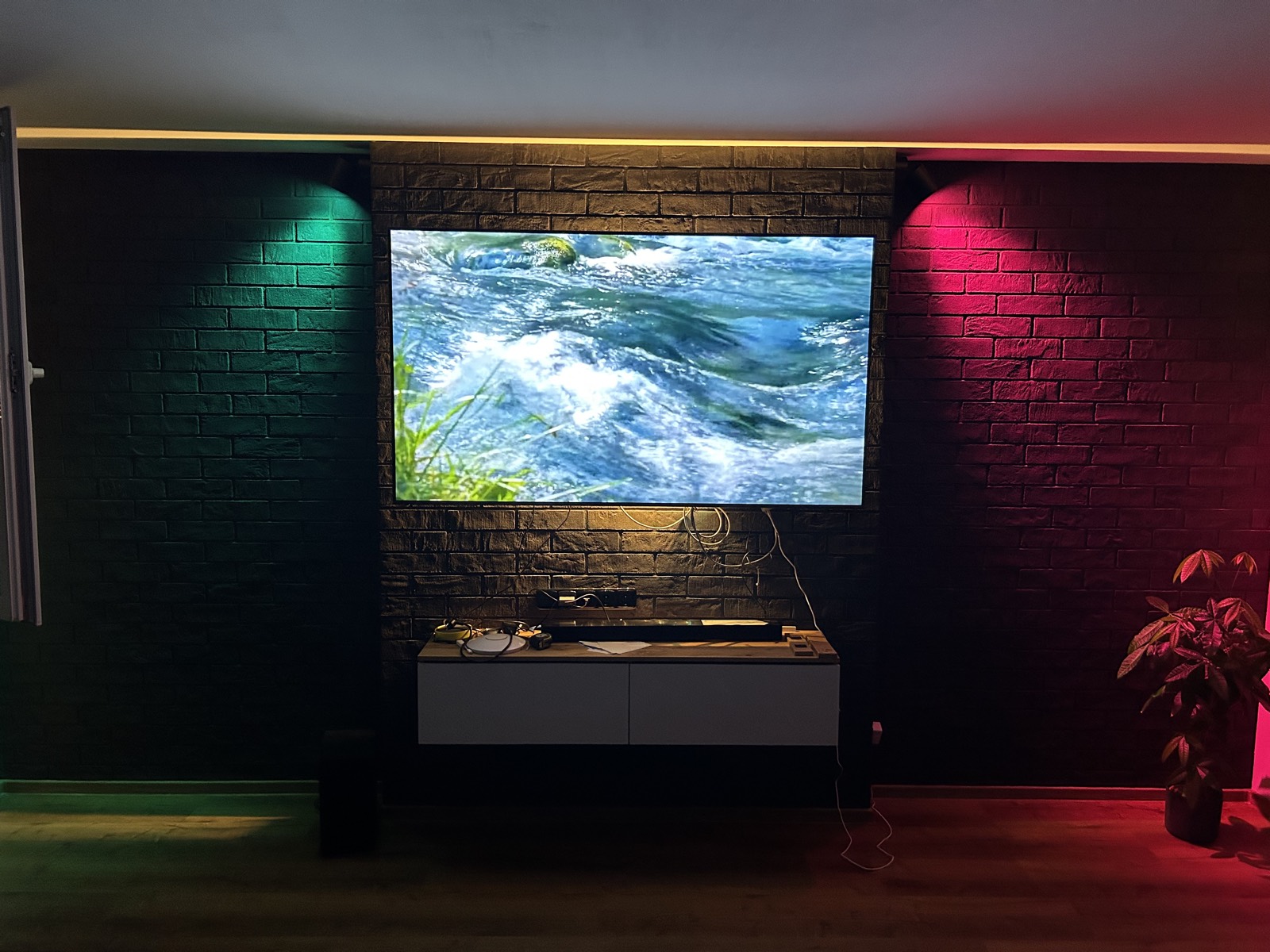 Obývací pokoj s tmavou cihlovou stěnou a RGB osvětlením po kompletní rekonstrukci bytu — Neratovice
