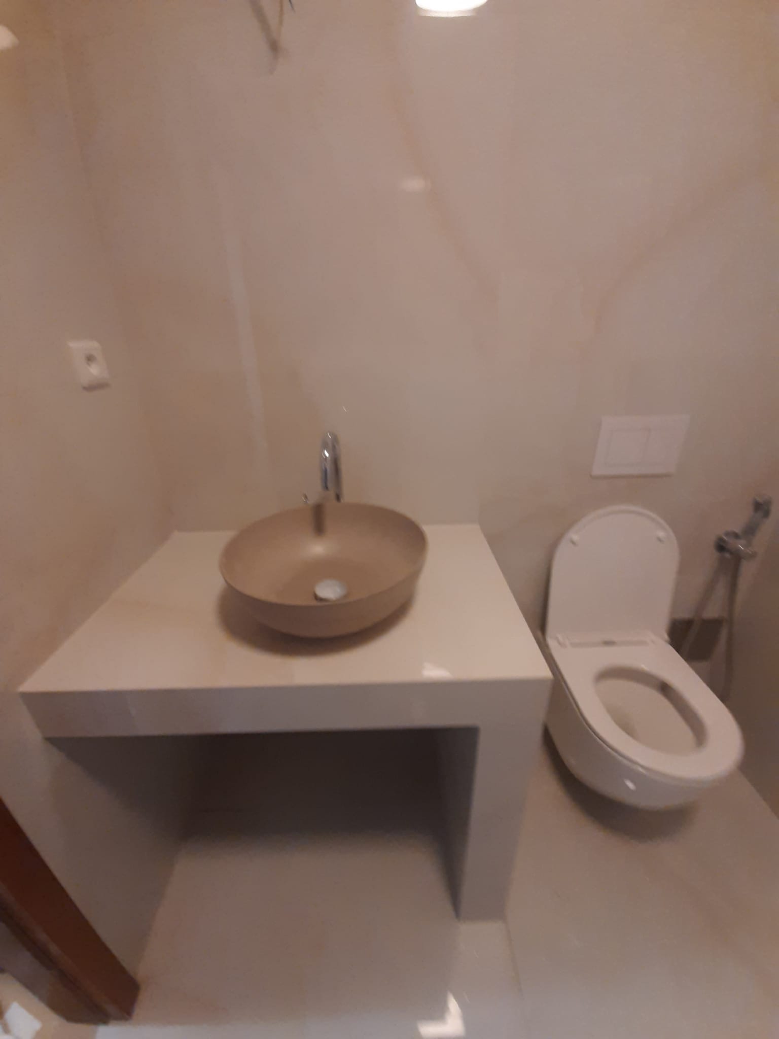 Rekonstruované WC se závěsnou toaletou, kamenným umyvadlem na desce a velkoformátovým obkladem — Praha, Můstek
